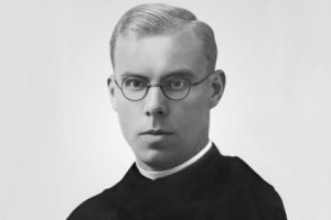 Portret błogosławionego Achillesa Puchały – franciszkanina w okrągłych okularach i habicie, na jasnym tle.