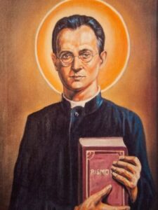 Błogosławiony Edward Grzymała, kapłan w sutannie z Pismem Świętym w dłoniach.